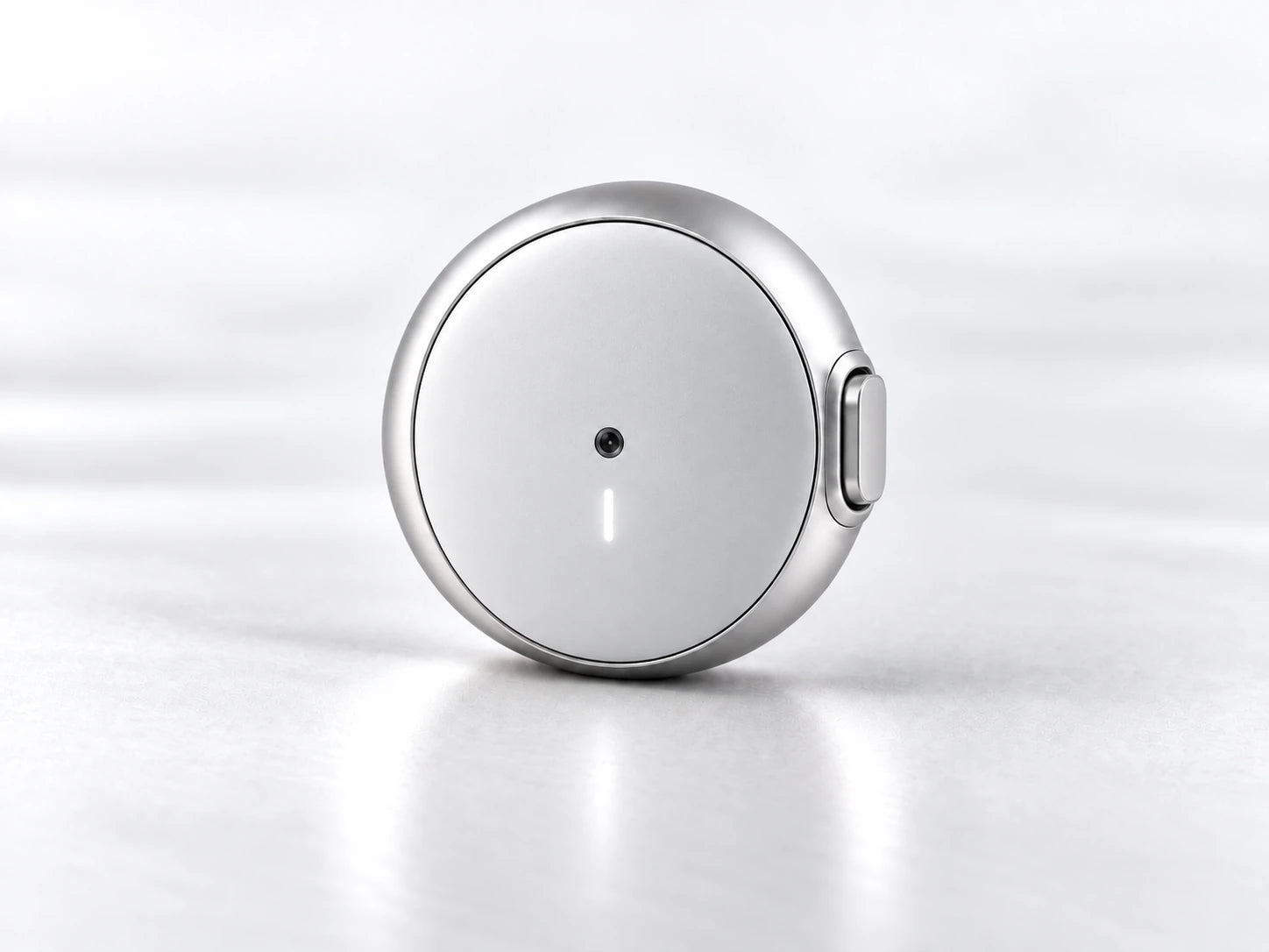 Next-generation round silver Prana wearable with its thin belt retracted inside the pod